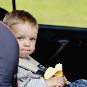 Kid With Banana In Car Seat