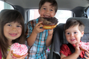 Children Eating Donuts In The Car